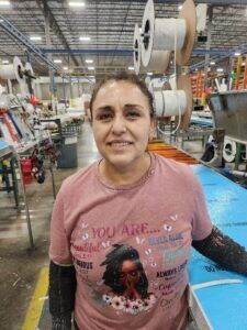 women smiling at camera at walk-in cooler manufacturing plant