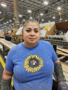 Women working on a line in a manufacturing plant looking at the camera