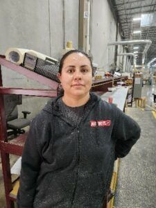 Women looking directly at camera in a manufacturing plant
