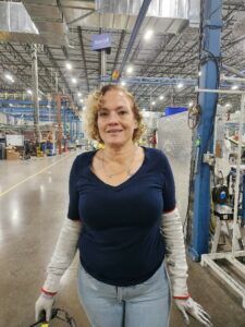 women posing for camera in manufacturing plant