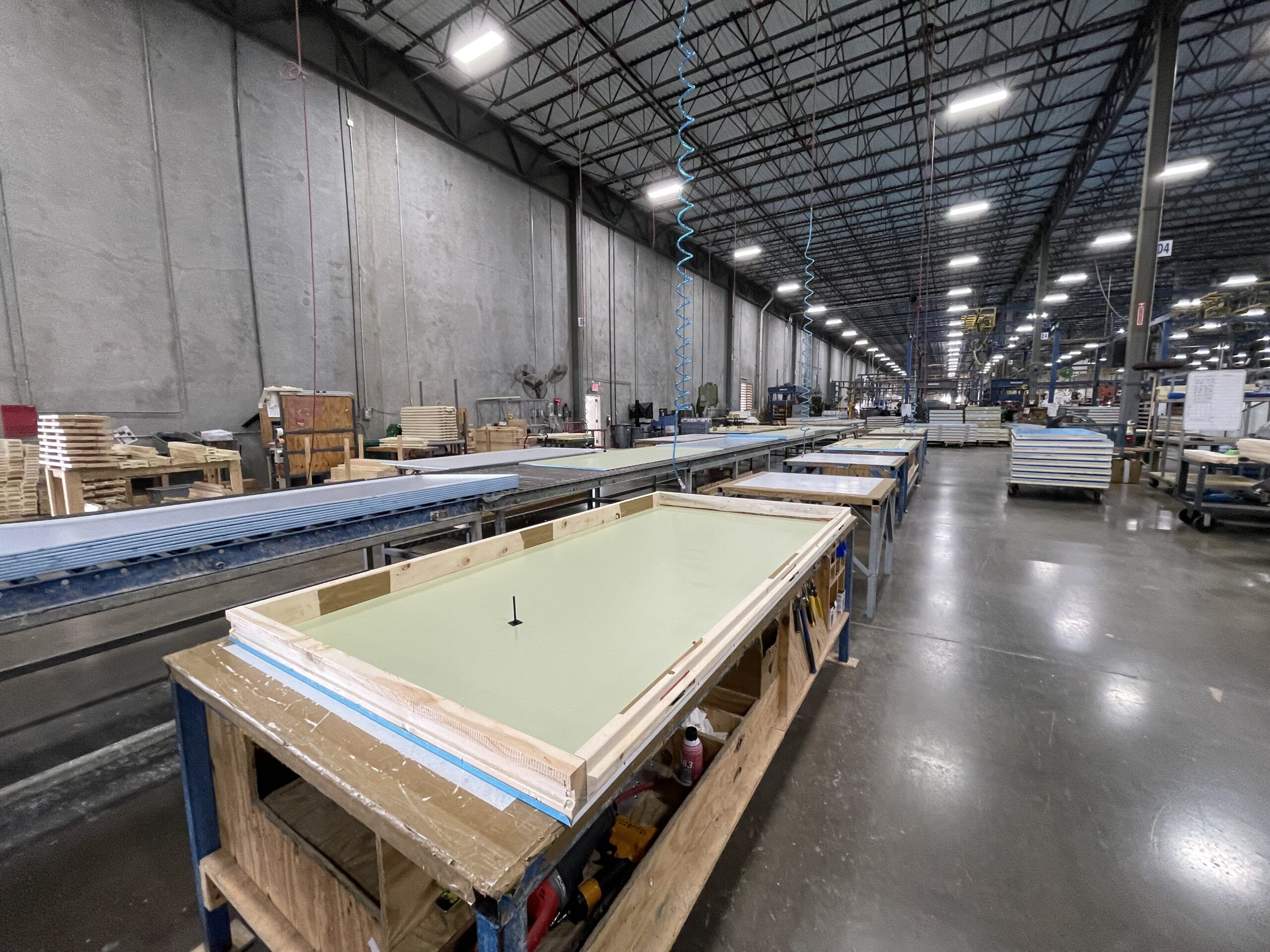 Manufacturing line with panels on tables waiting to go through the next step.