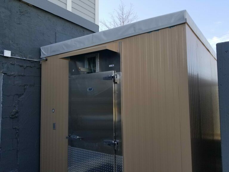 Outdoor walk-in cooler with a membrane roof. Metal free standing building with a rubber roof used to hold contents that require temperature control.