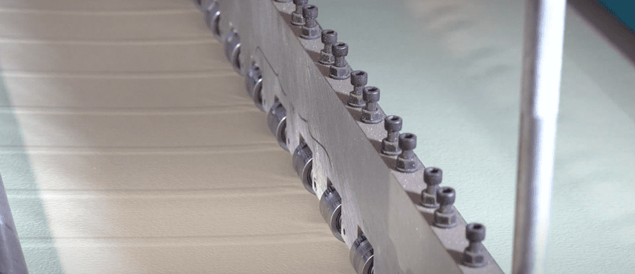 Roll form machine that uses rollers to alternate thicknesses in the metal skins of outdoor equipment enclosures